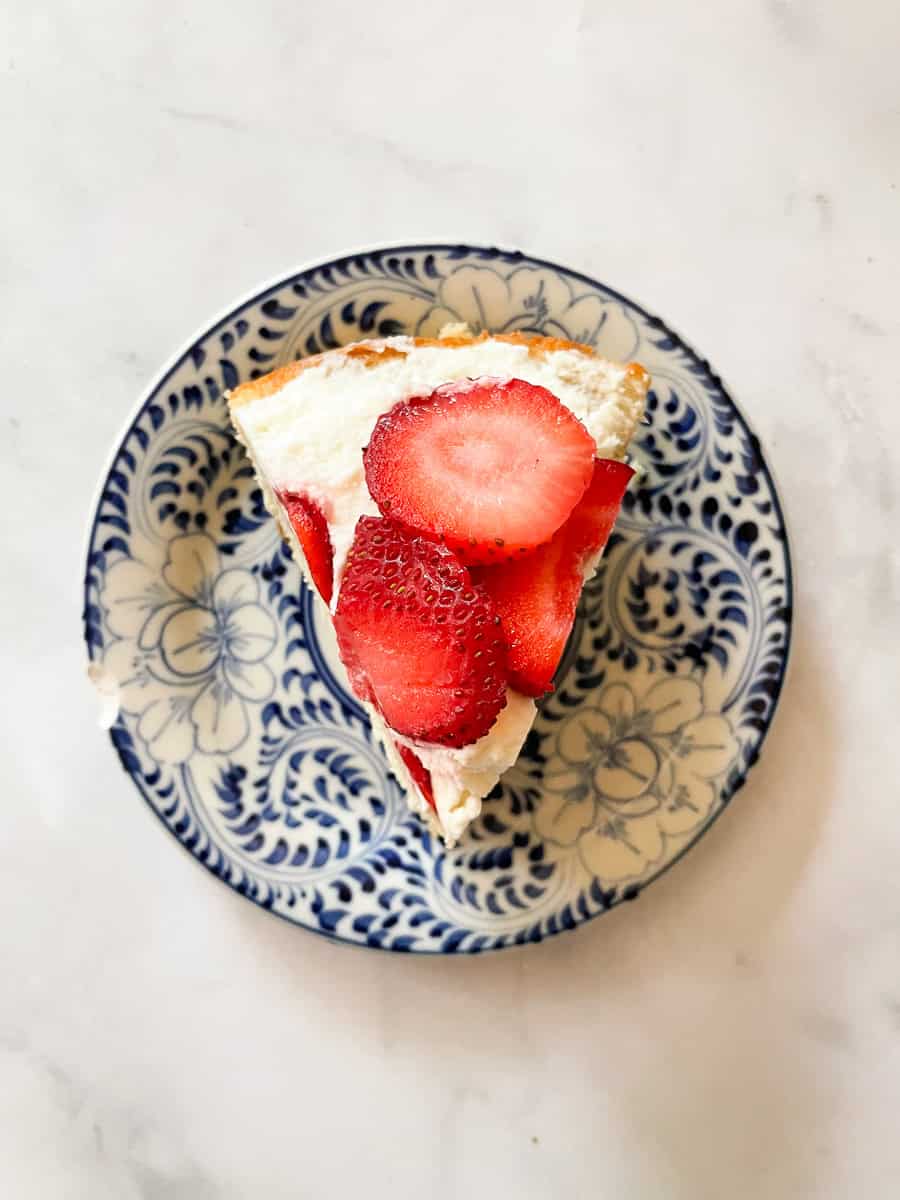 A piece of gluten free strawberry shortcake on a blue and white plate.