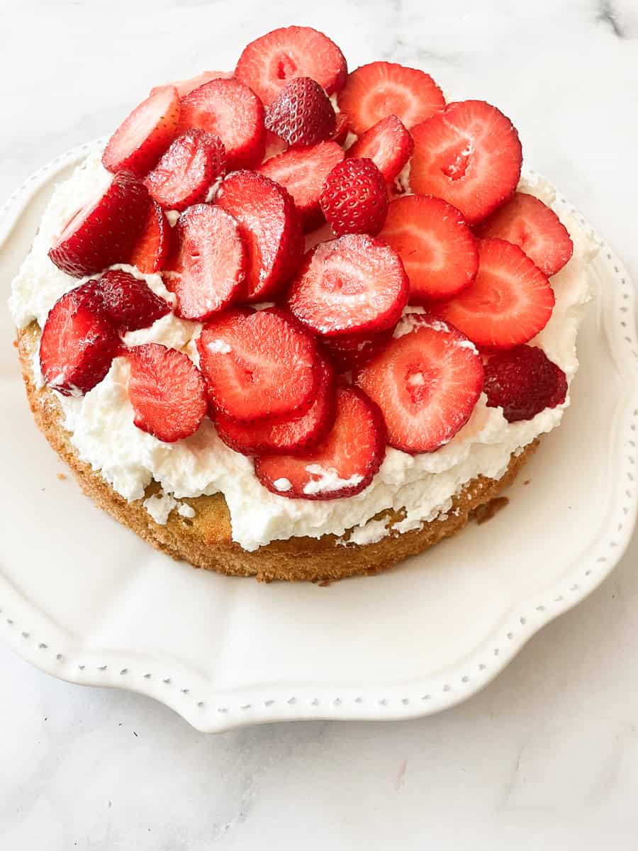 A gluten free strawberry shortcake cake on a white plate.