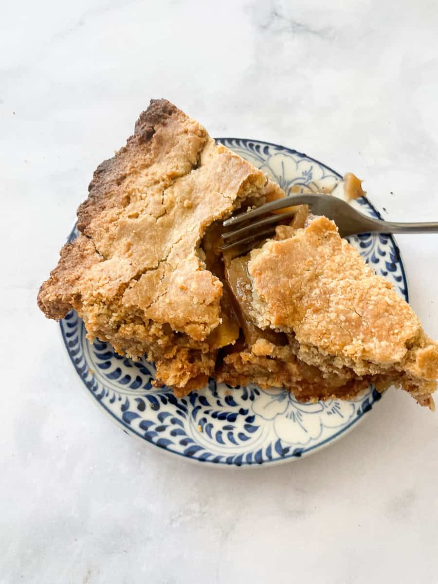 A fork cuts into a slice of gluten free apple ple.