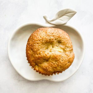 A gluten free apple muffin on an apple plate.