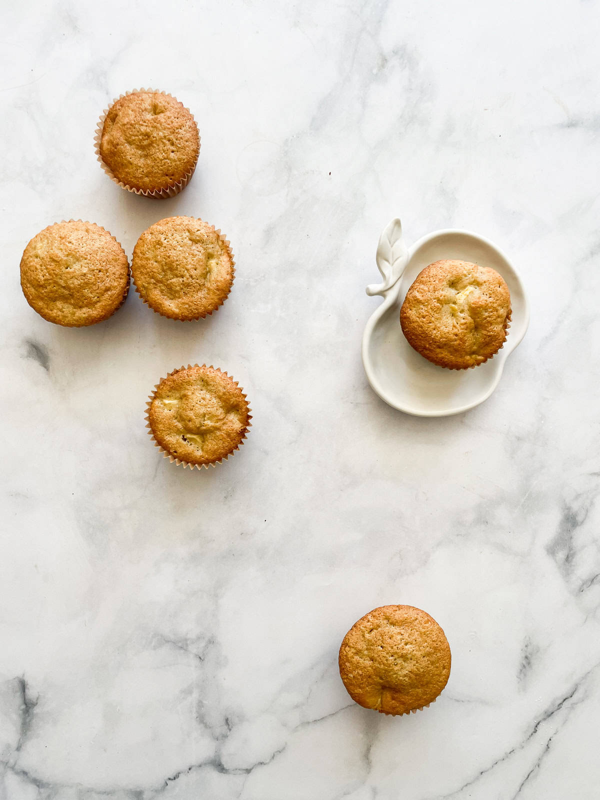 Apple muffins with one on a plate.