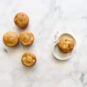 Apple muffins with one on a plate.