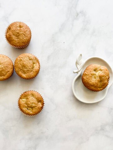 Apple muffins with one on a plate.