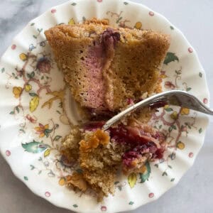 A fork cuts into a piece of plum torte.