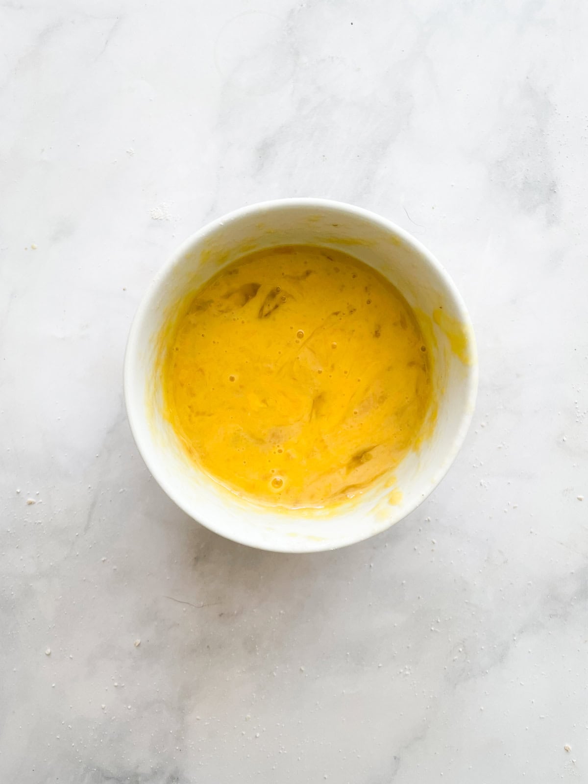 Eggs whisked in a bowl.