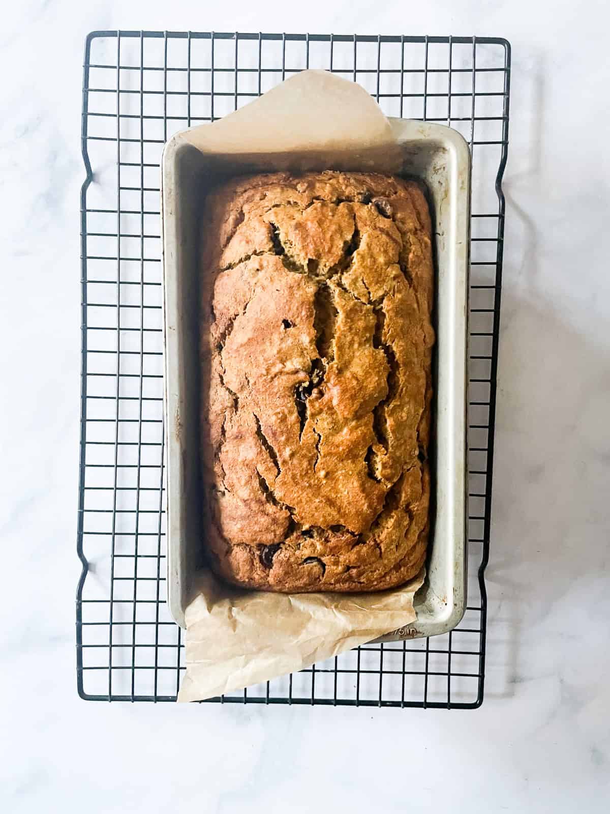 A gluten free pumpkin banana bread cool on a rack.