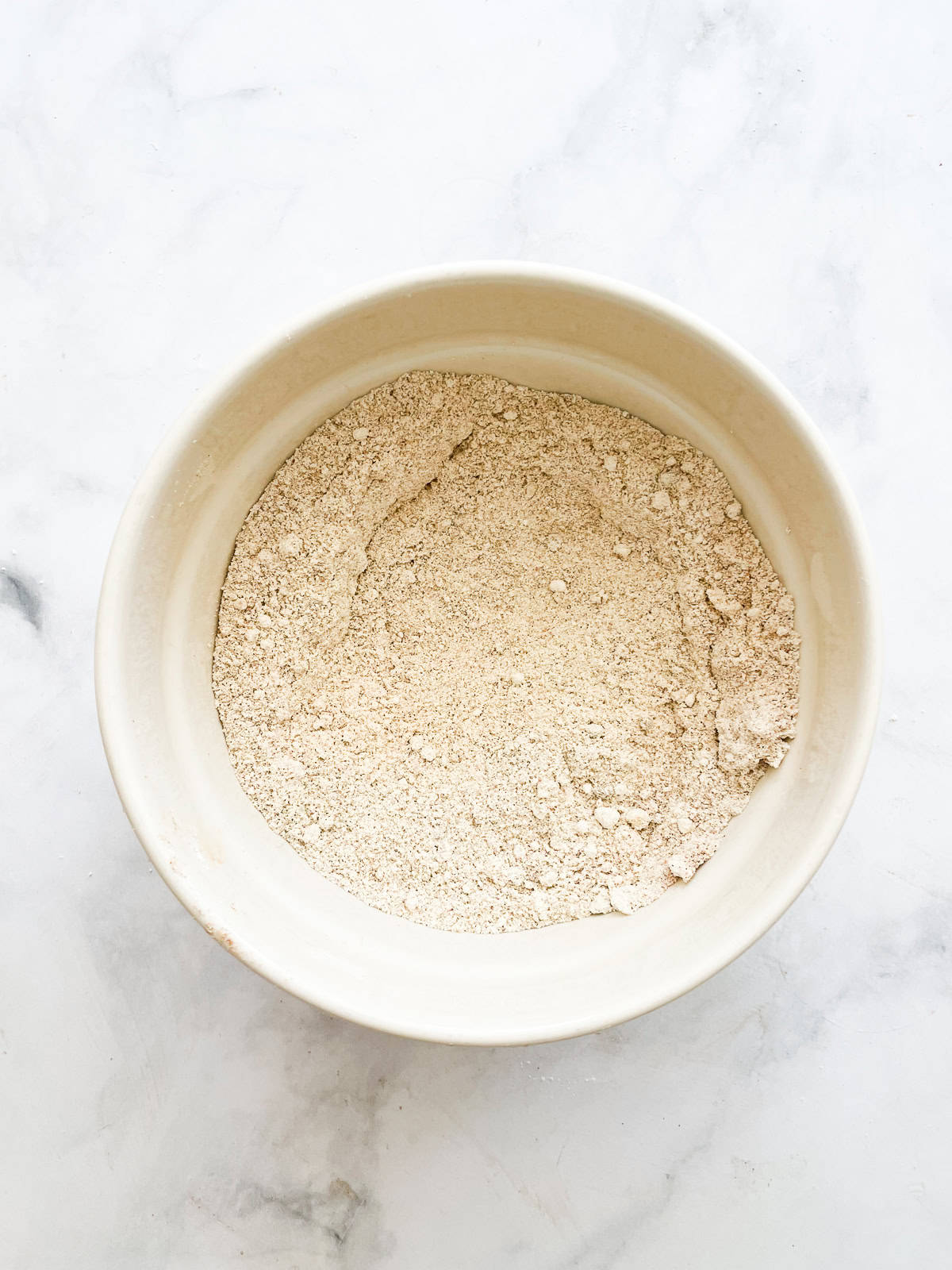 Flour is mixed for pumpkin bread in a bowl.