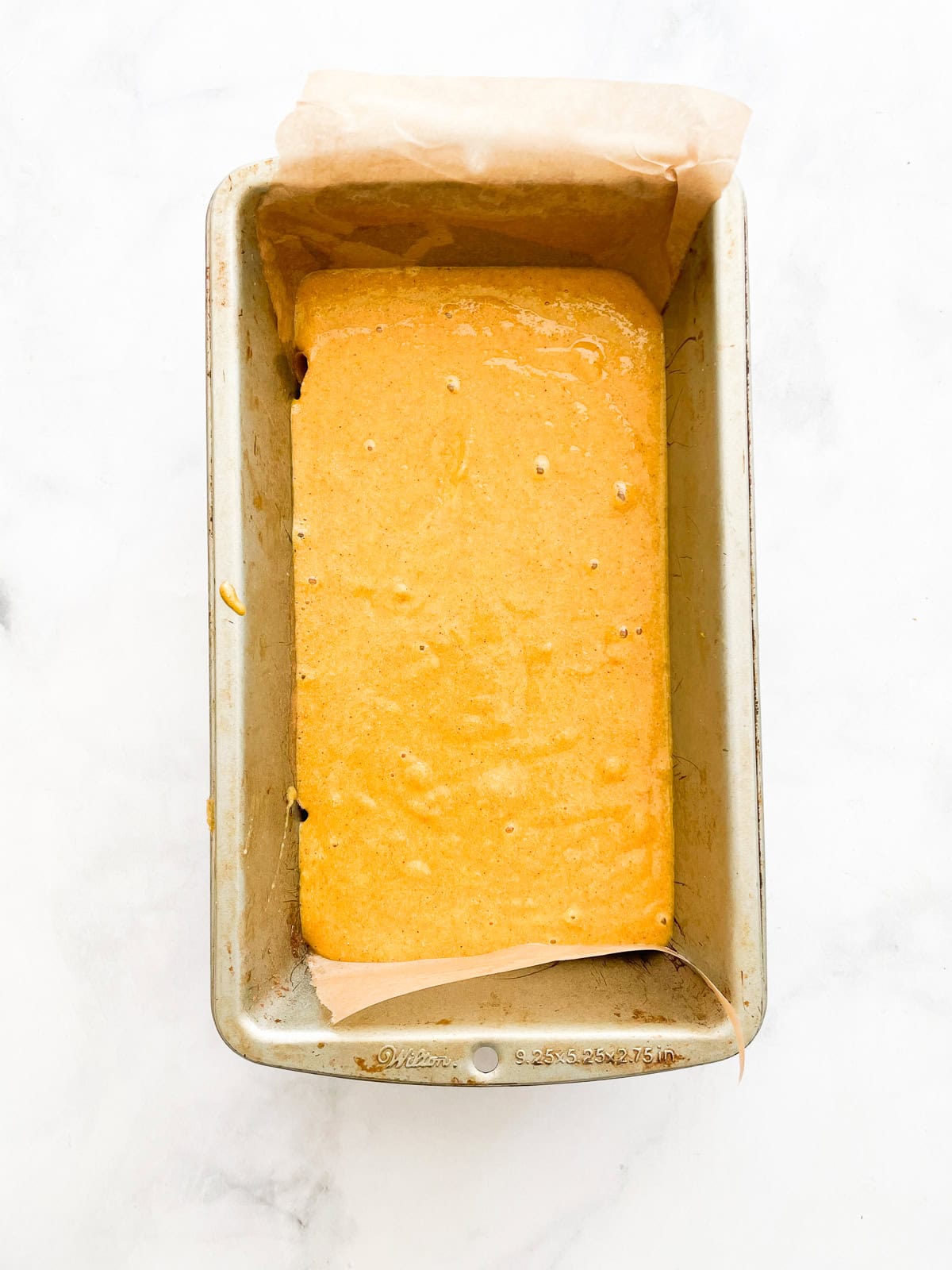 Pumpkin batter in a loaf pan.