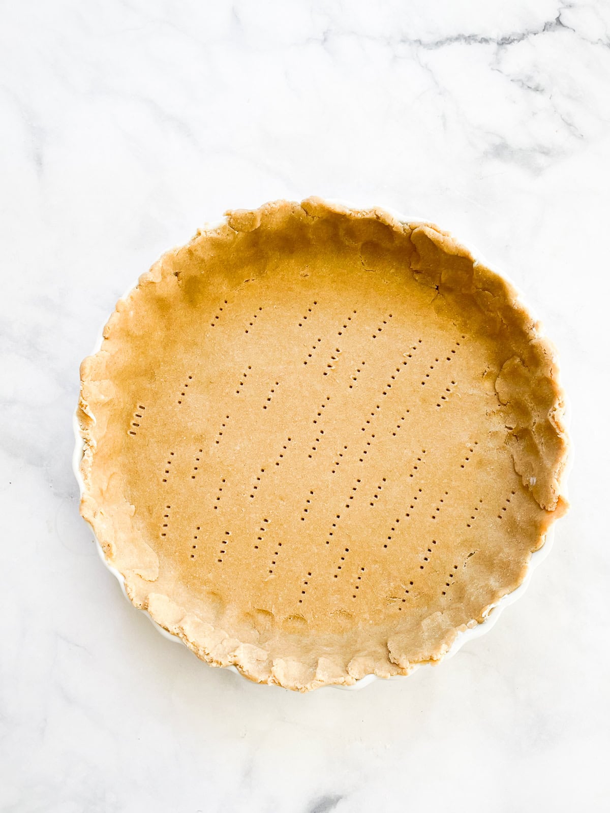 A gluten free all butter pie crust in a pie dish.