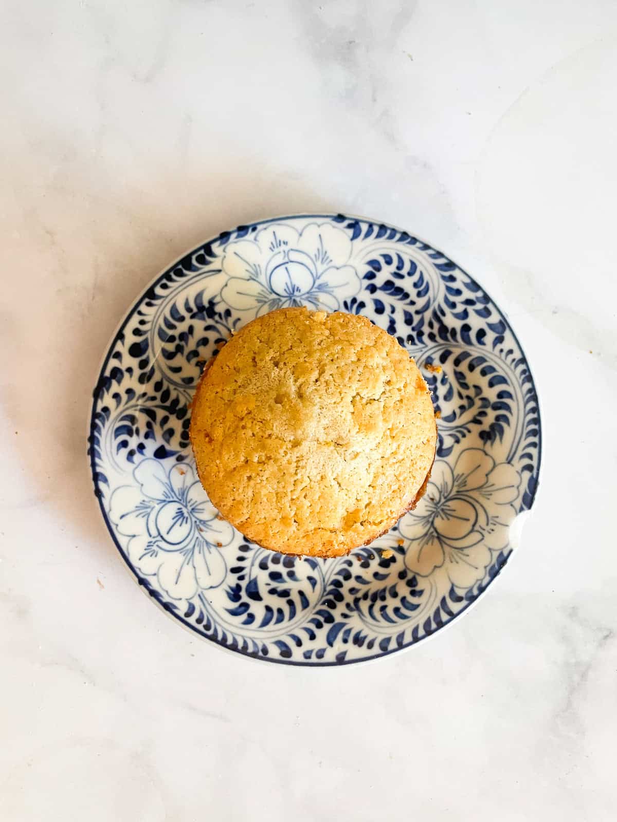 A honey cornbread muffin on a blue and white plate.