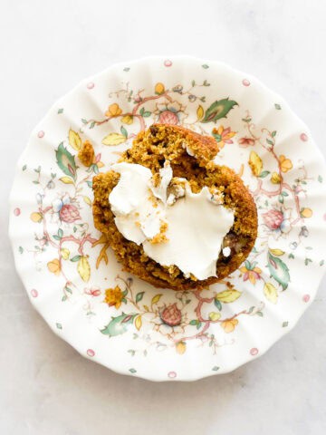 Cream cheese on half of a pumpkin banana muffin.