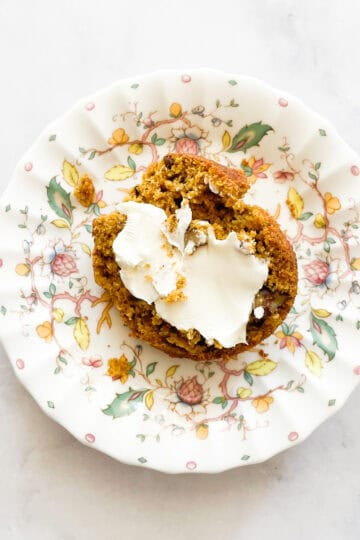 Cream cheese on half of a pumpkin banana muffin.
