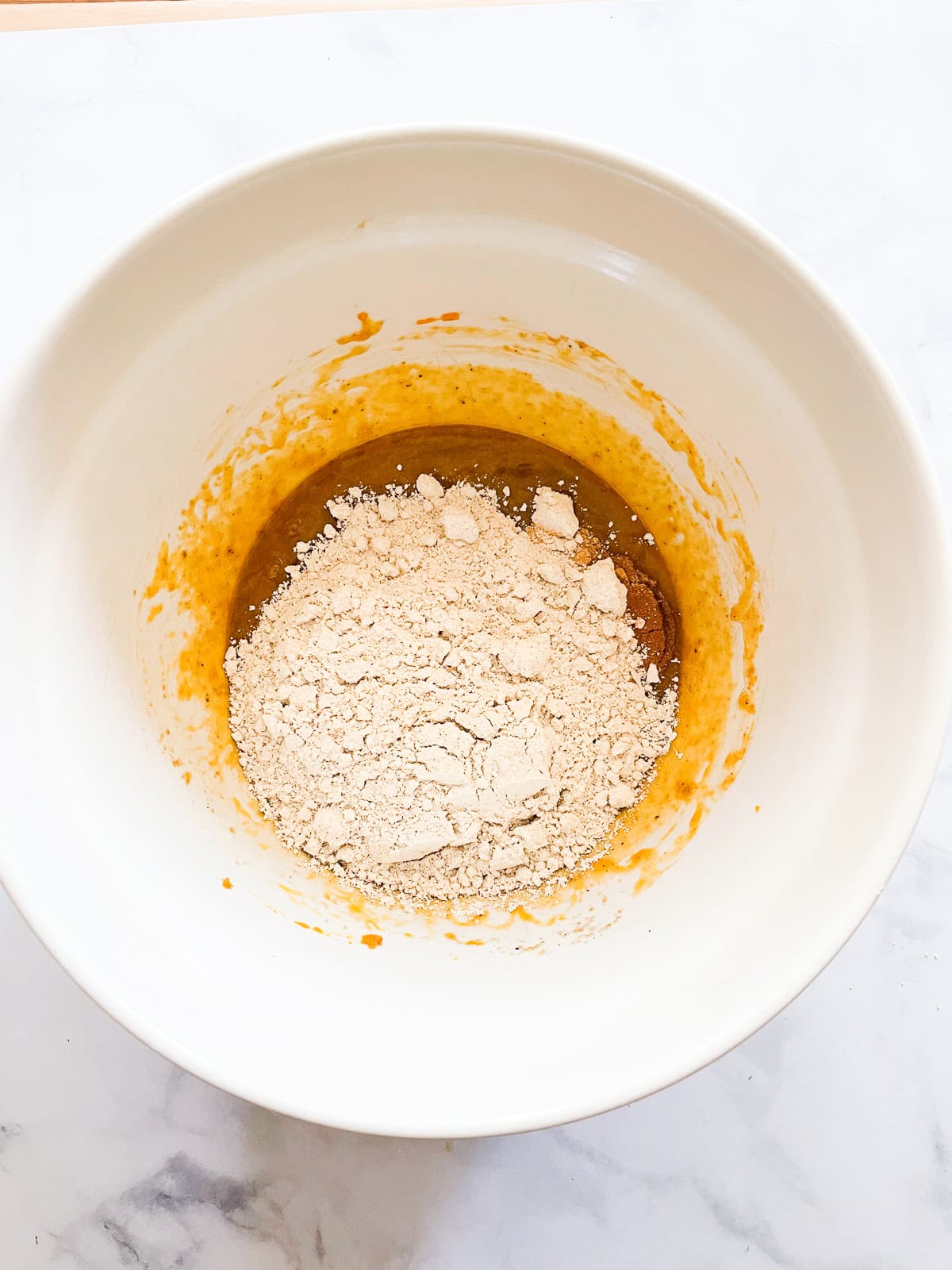 Flour, spices, and baking soda are added to the pumpkin mixture.