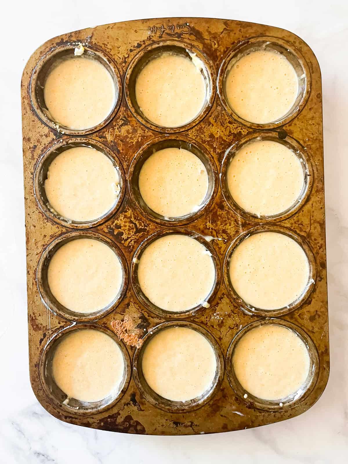 Cornbread batter in a muffin tin.