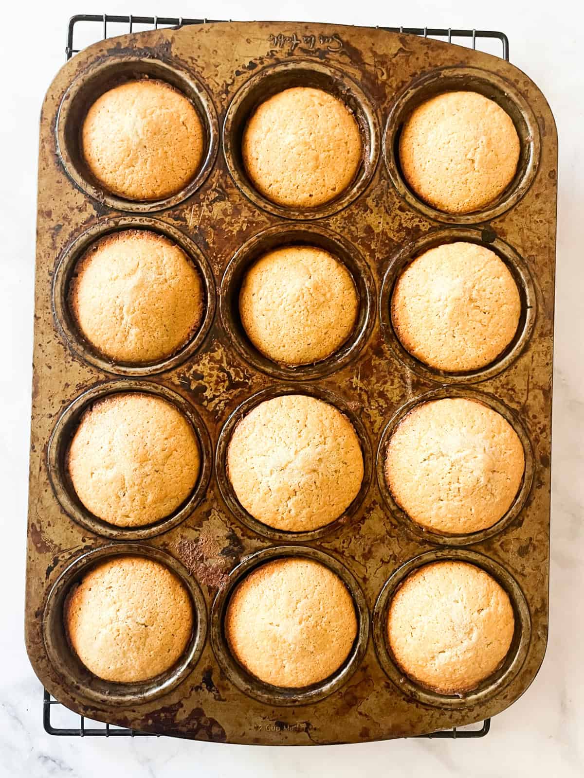 Baked cornbread muffins in a tin.