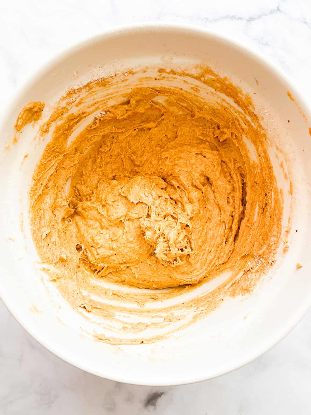 Flour is added to pumpkin banana muffin batter.