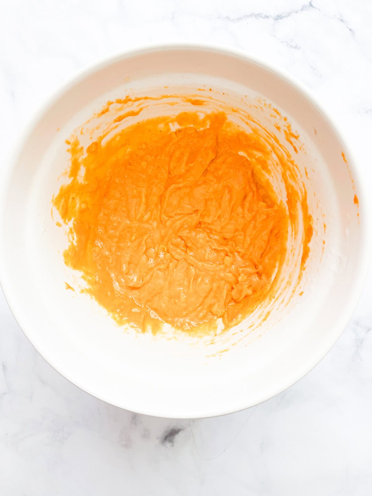 Wet mix for pumpkin banana muffins in a bowl.