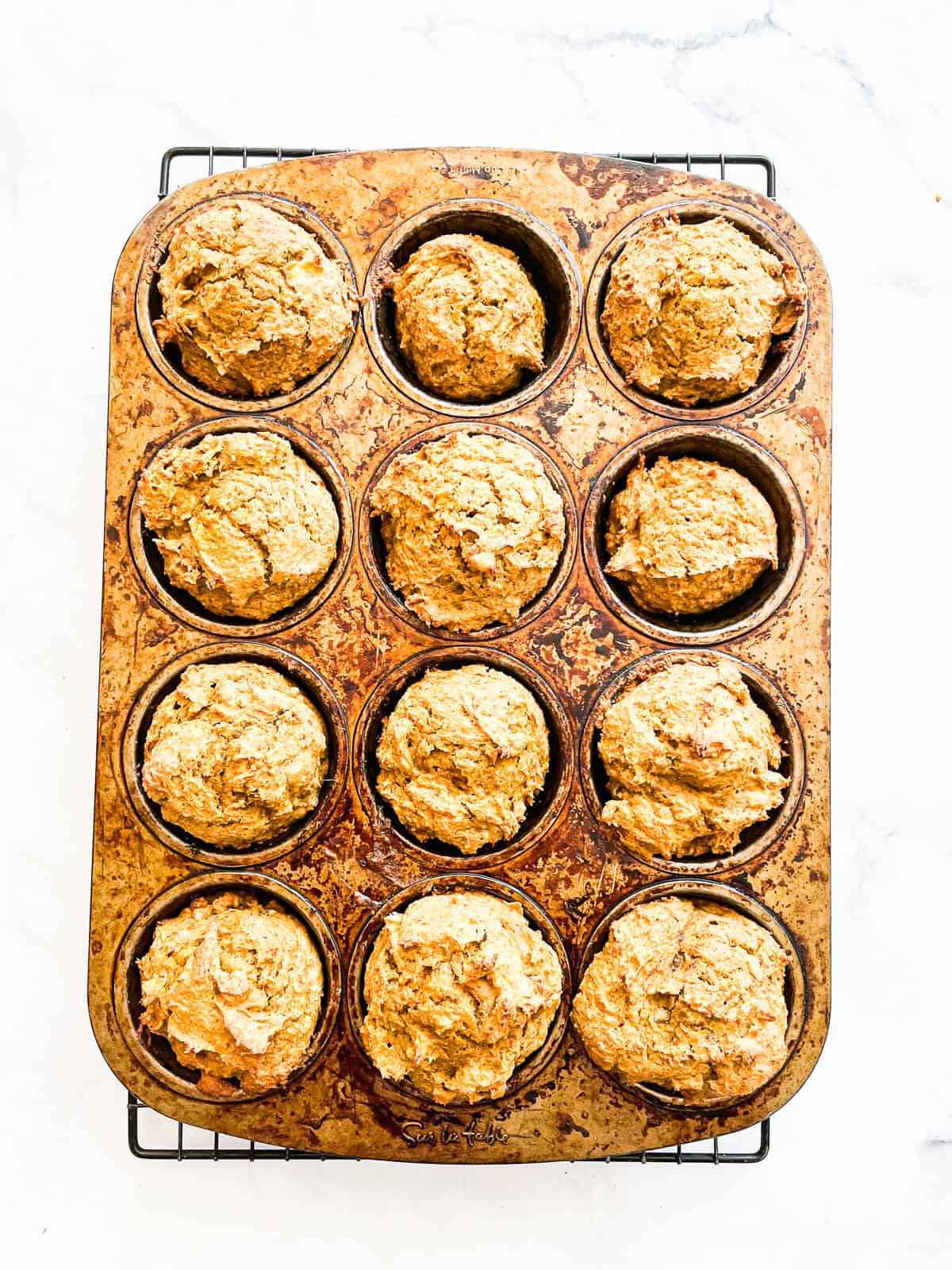 Gluten free pumpkin banana muffins cool in a tin.