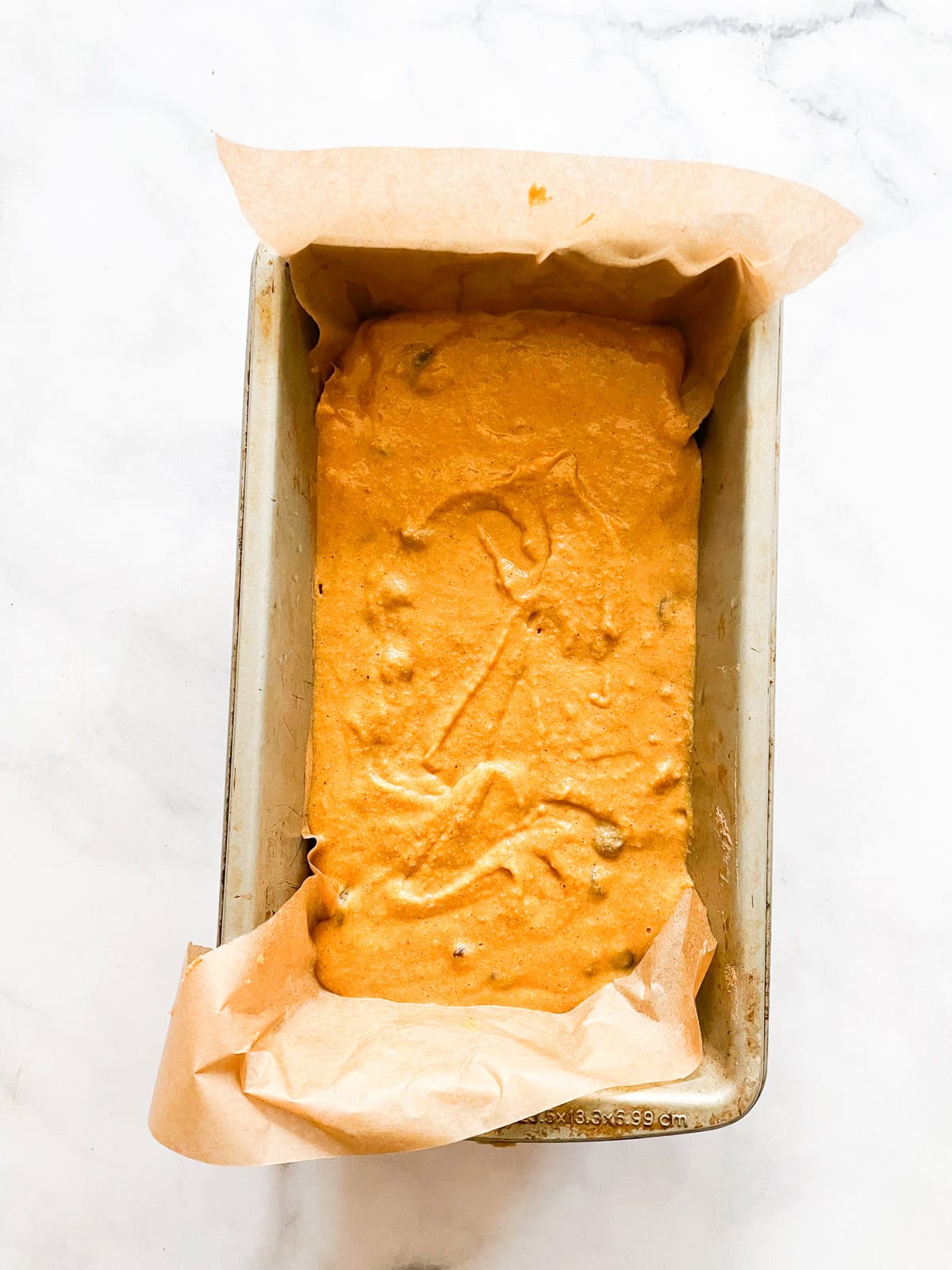 Gluten free pumpkin chocolate chip bread batter in a loaf pan.