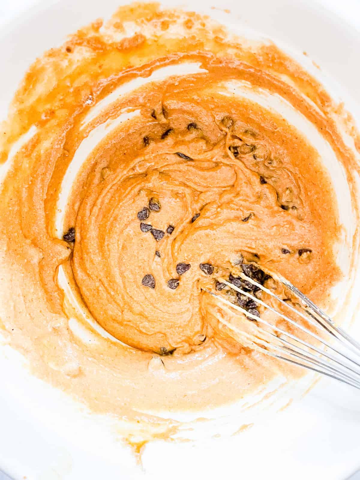 Chocolate chips are whisked into pumpkin bread batter.