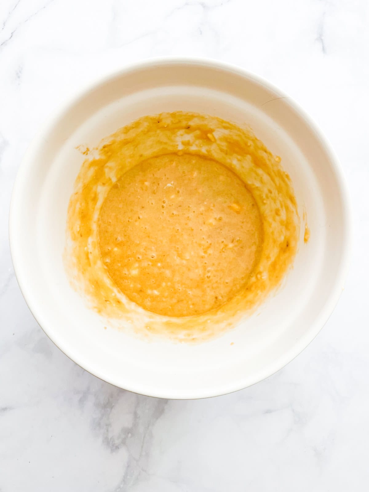 Liquid ingredients for oat flour banana bread mixed in a bowl.