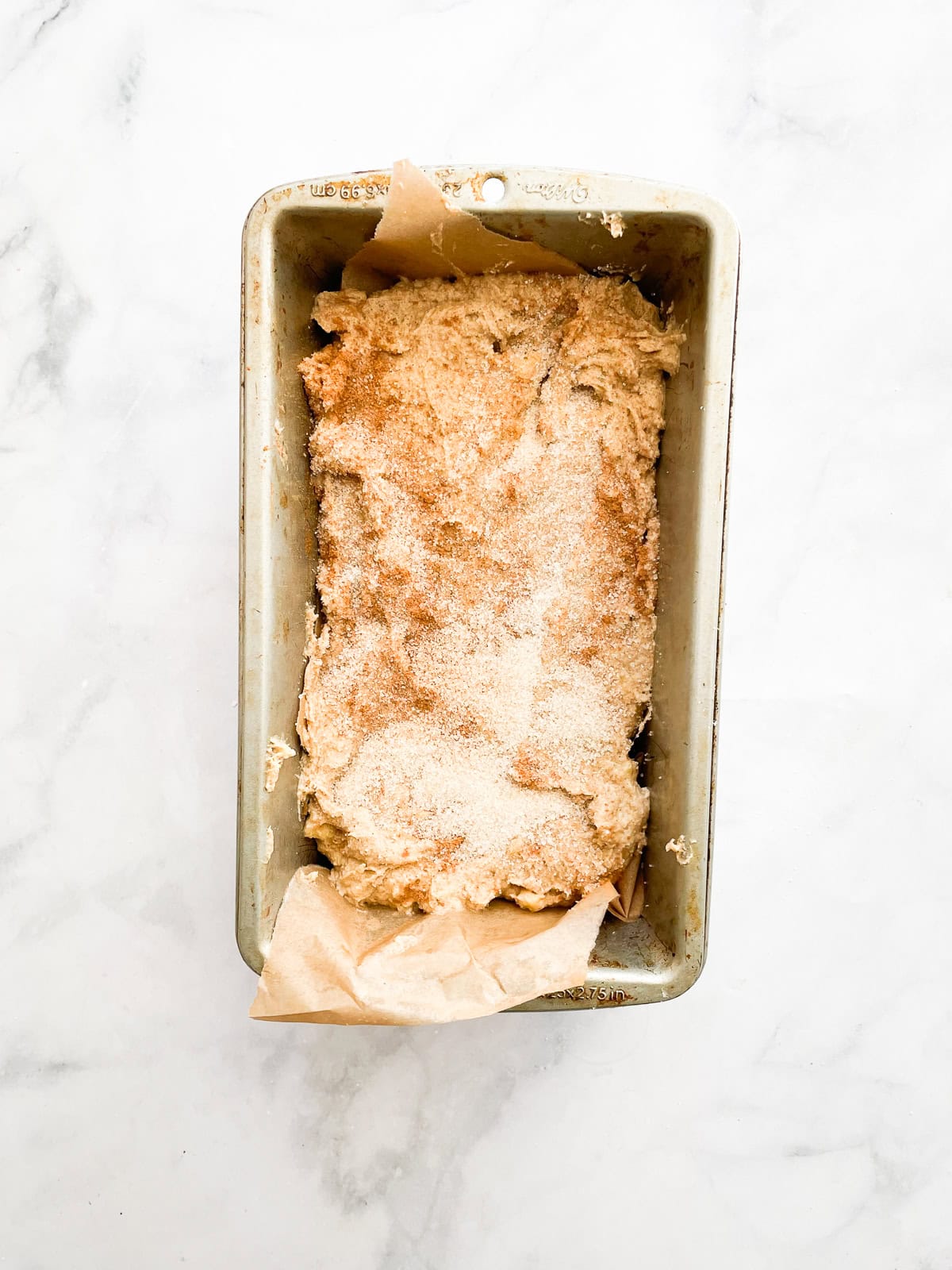 Oat flour banana bread topped with cinnamon sugar in a baking tin.