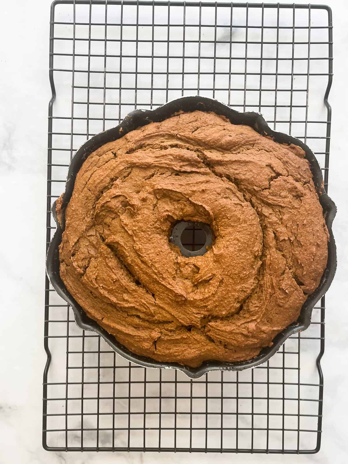 A pumpkin cake cools in a pan.