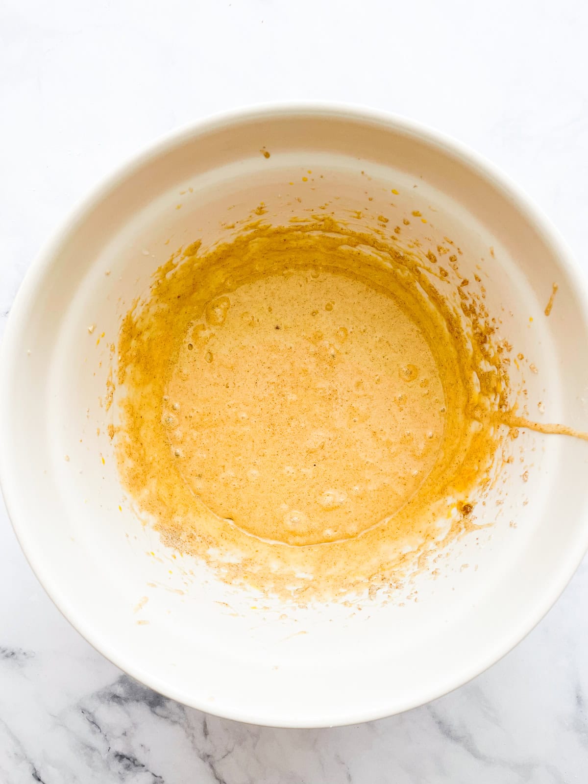 Eggs added to creamed butter in a bowl.