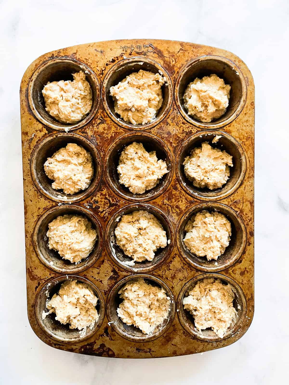 Leftover oatmeal muffins batter in a muffin tin.