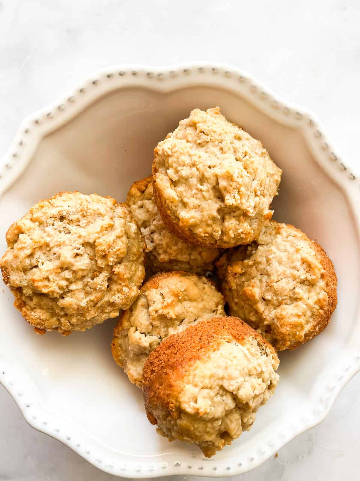 Leftover oatmeal muffins in a white bowl.