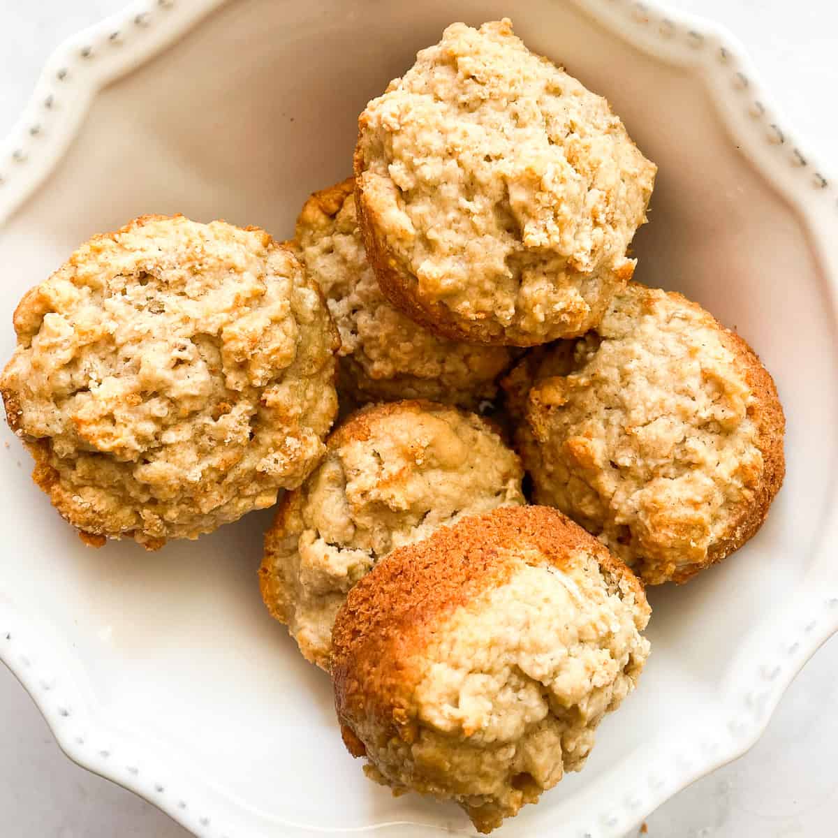 Leftover oatmeal muffins in a white bowl.