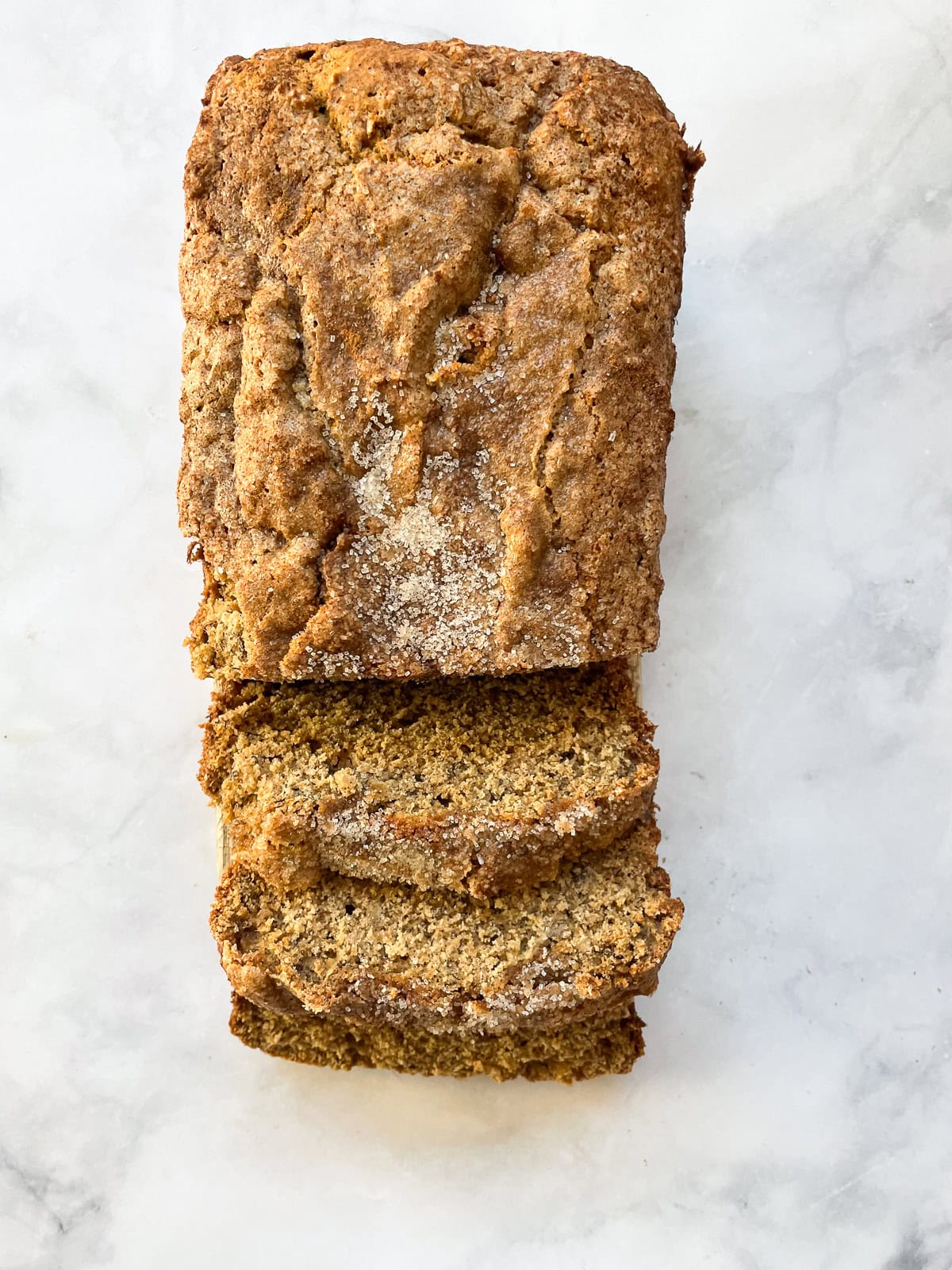 A loaf of oat flour banana bread cut in slices.