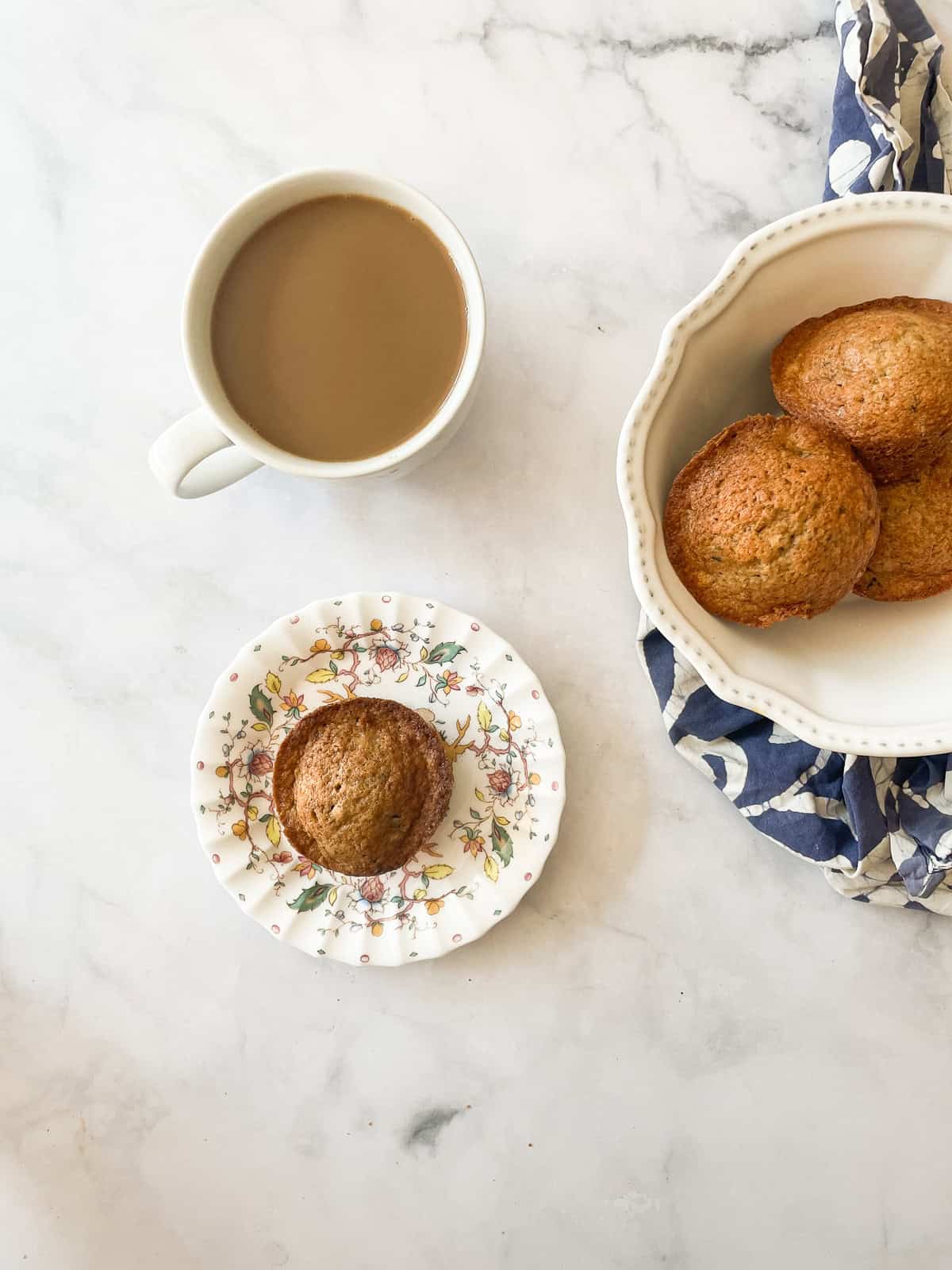 A bowl of banana chocolate chunk muffins and a cup of coffee.