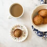 A bowl of banana chocolate chunk muffins and a cup of coffee.