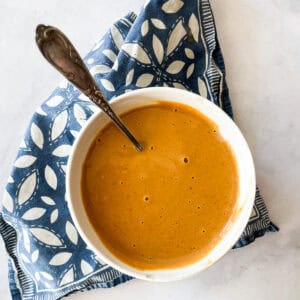 A bowl of ginger peanut sauce on a blue napkin.