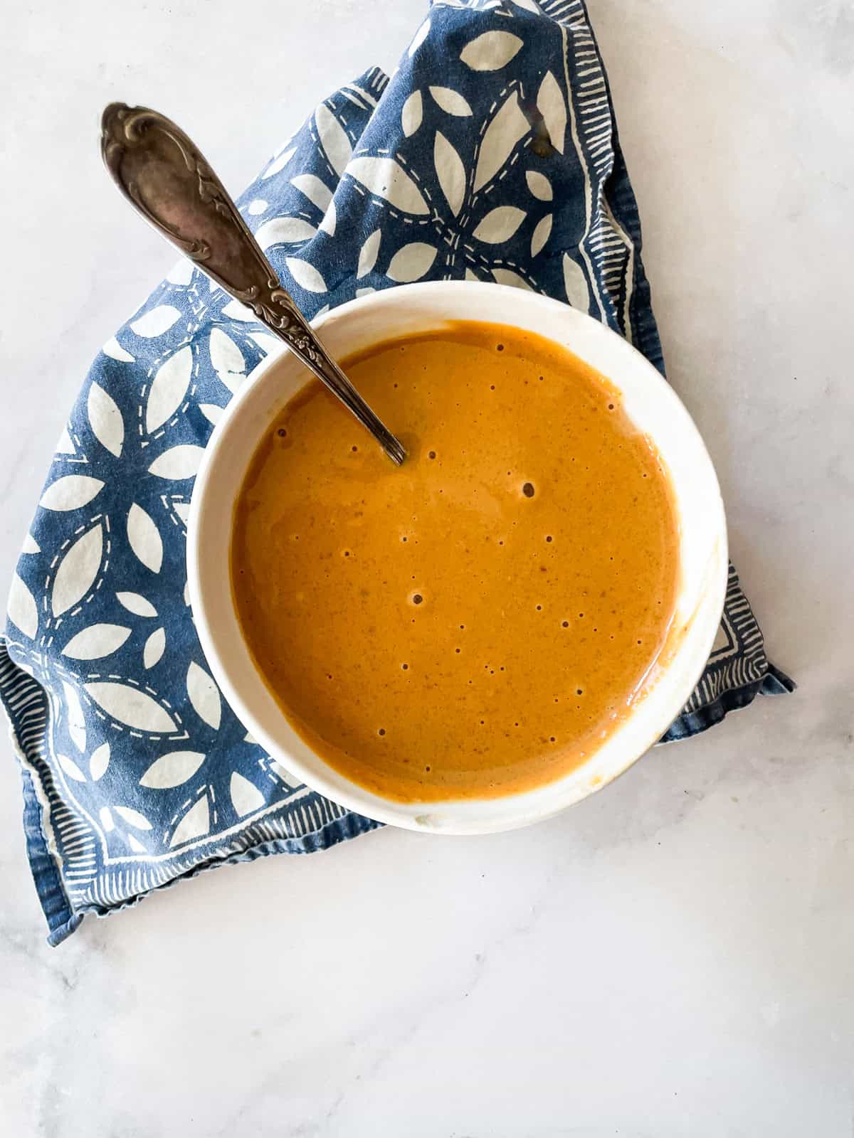 A bowl of ginger peanut sauce on a blue napkin.