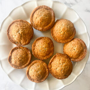 Gluten free chocolate chunk banana muffins on a cake plate.