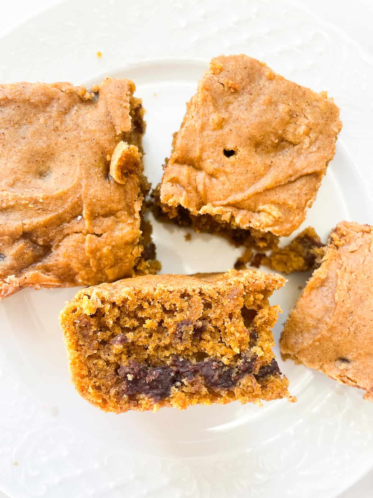 Slices of pumpkin chocolate chip cake on a plate, one is turned on its side.