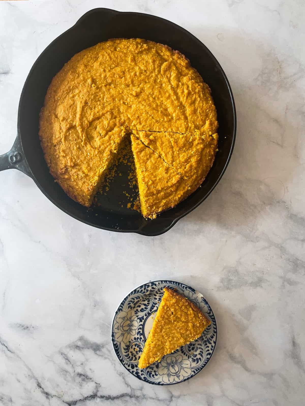 A pan of pumpkin cornbread and a slice of cornbread on a plate.