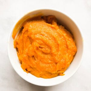 A white bowl of homemade pumpkin puree.