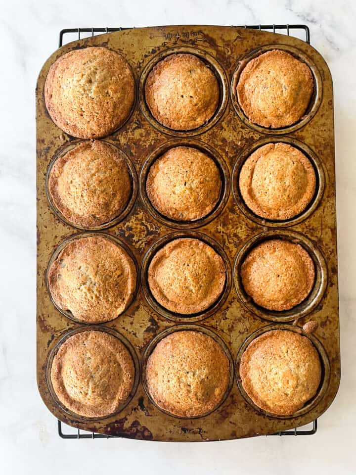 Baked banana chocolate chunk muffins cool in the pan.