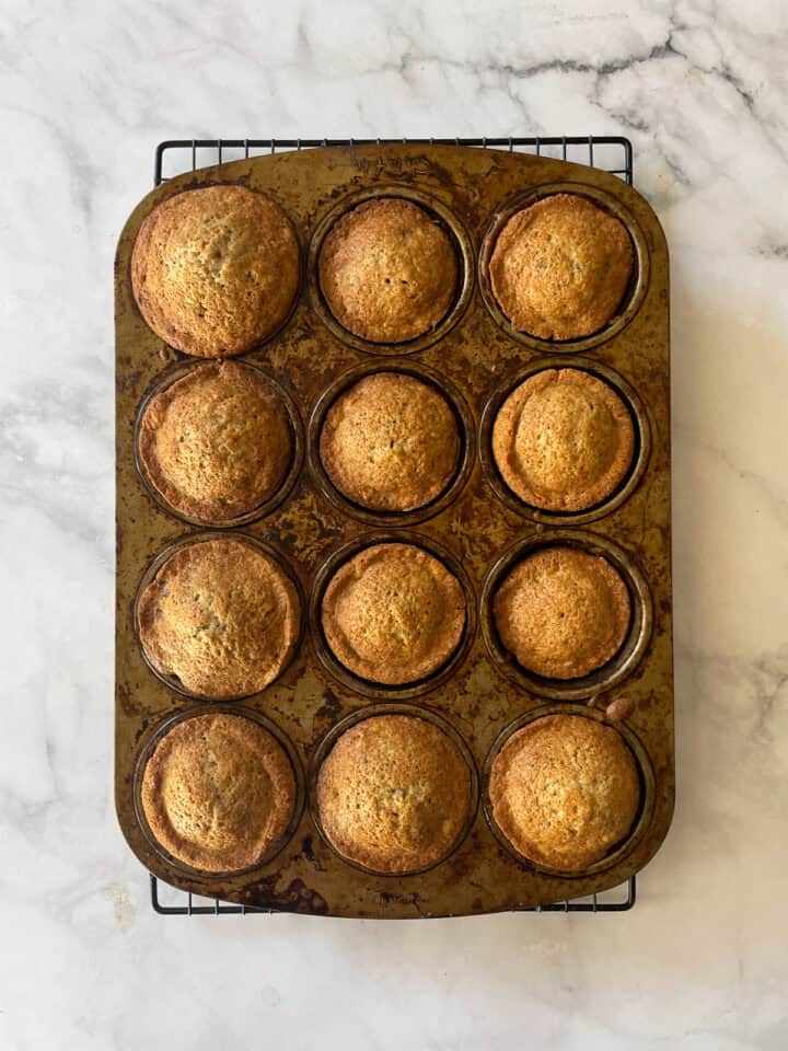 A baked batch of gluten free chocolate chunk banana muffins.