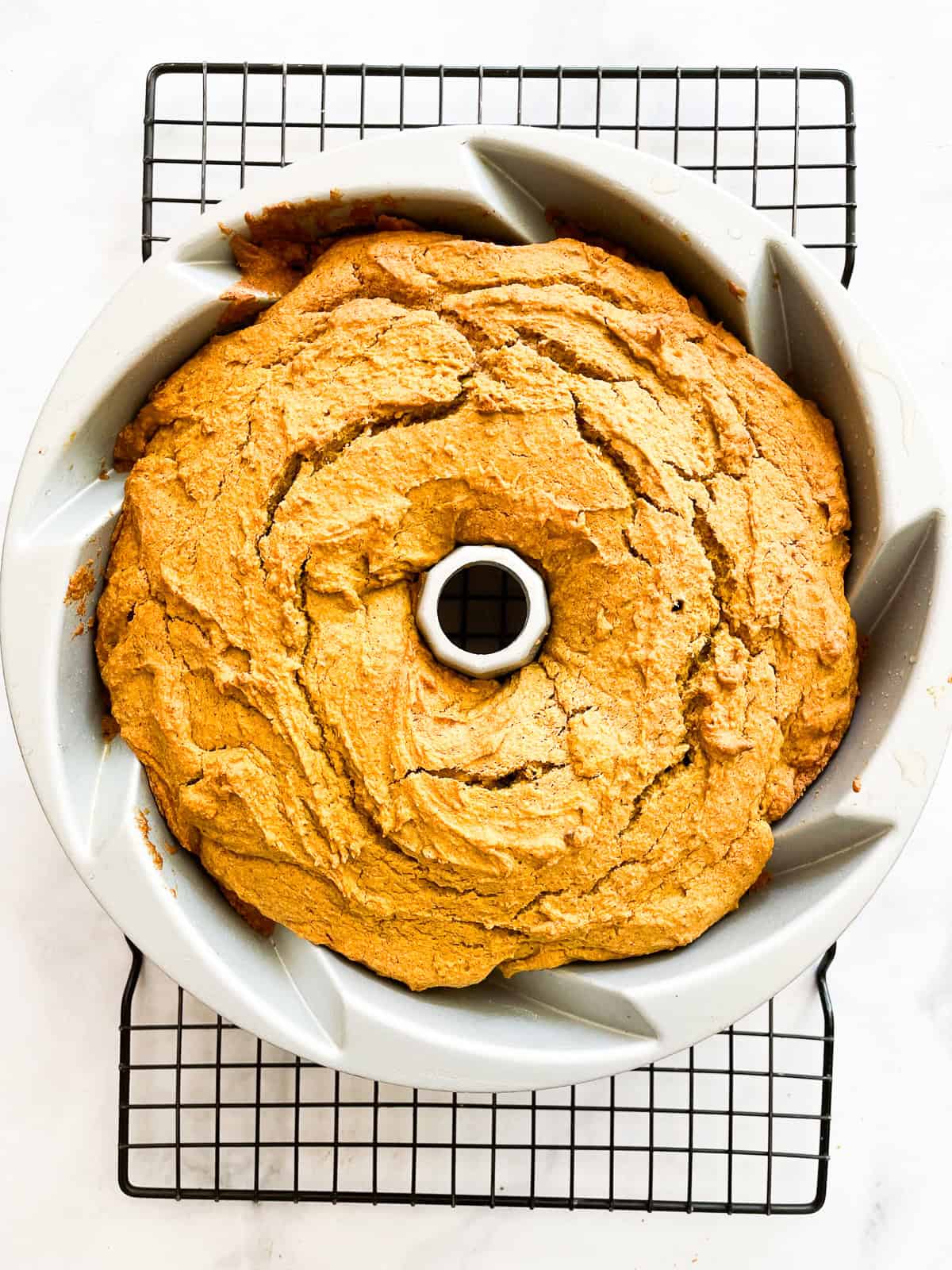 A gluten free pumpkin bundt cake cools in the tin.