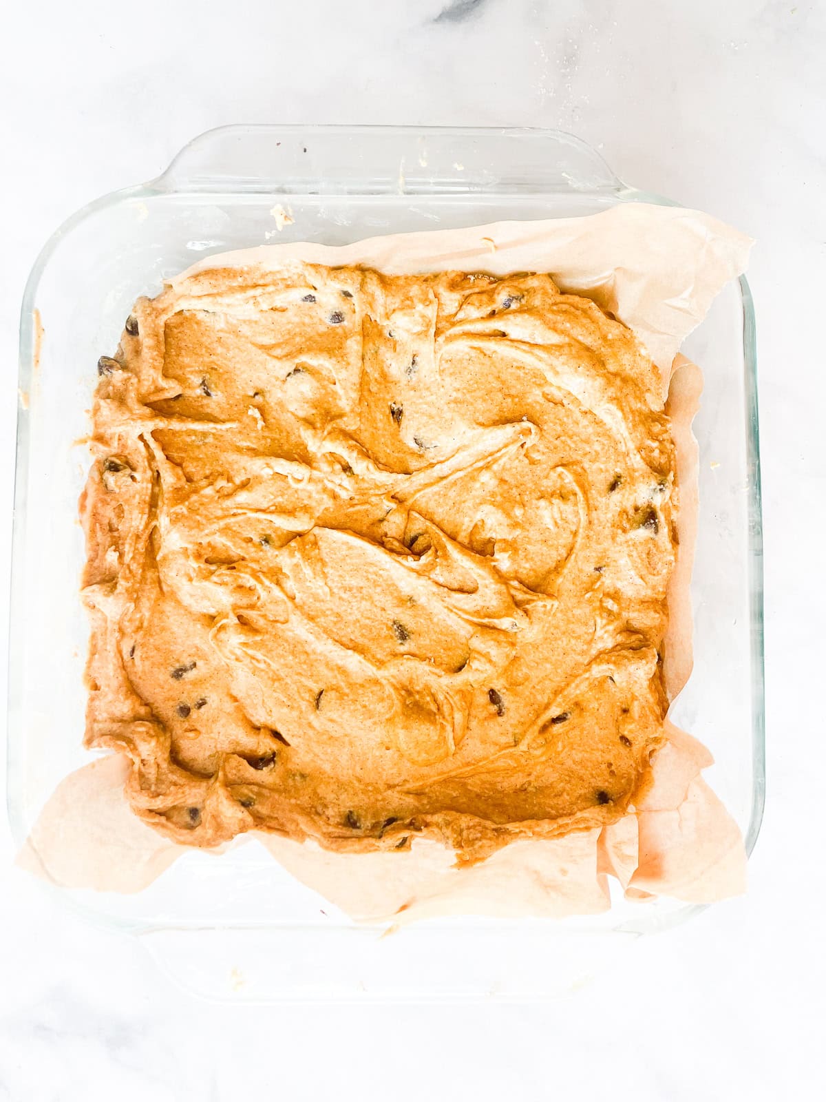 Pumpkin chocolate chip cake batter in a pan.