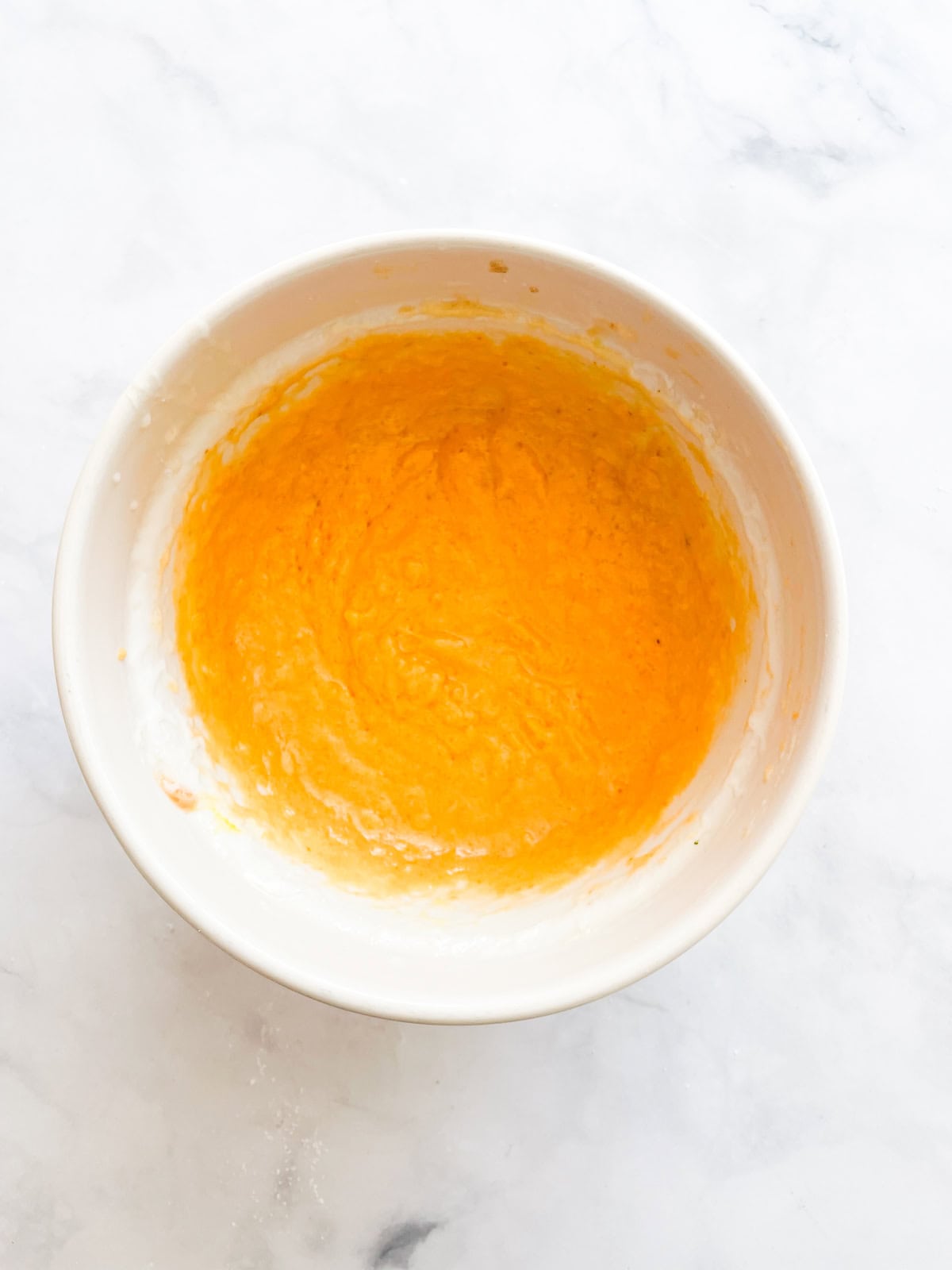 Pumpkin and oil mixed in a bowl.