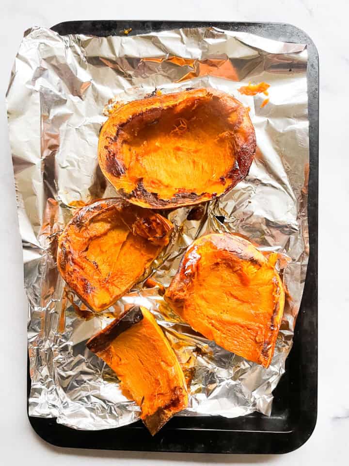 Pieces of roasted pumpkin on a baking sheet.