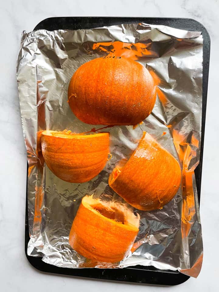 Pieces of pumpkin on a baking sheet.