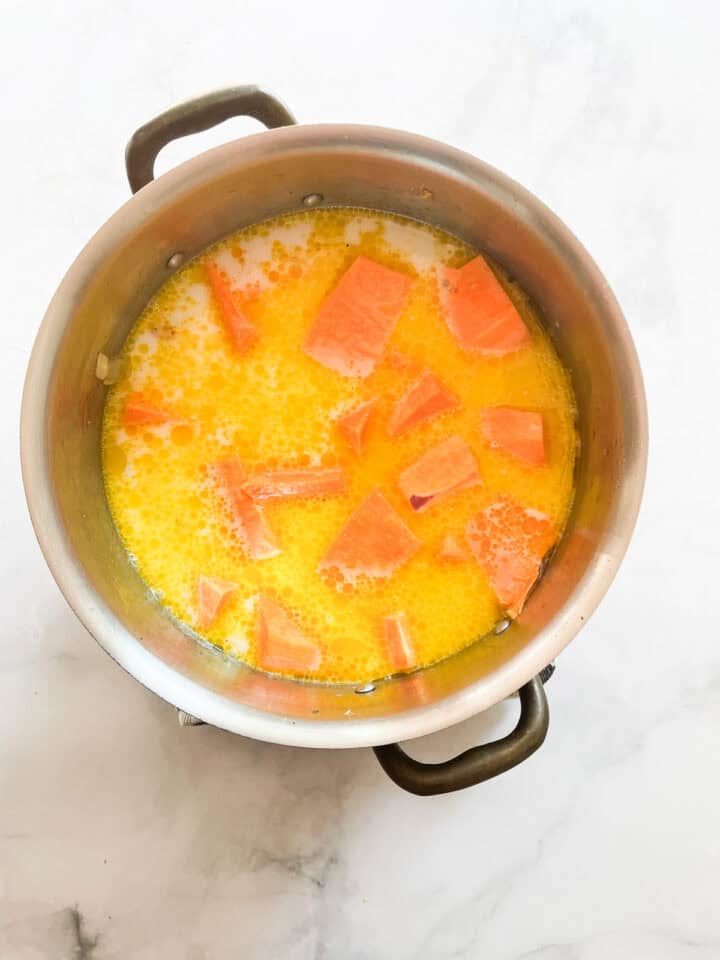 Broth and coconut milk added to soup.