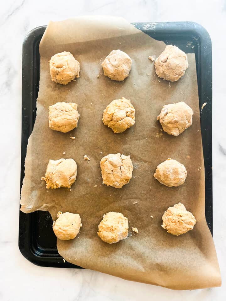 Twelve sweet potato biscuits on a baking sheet.