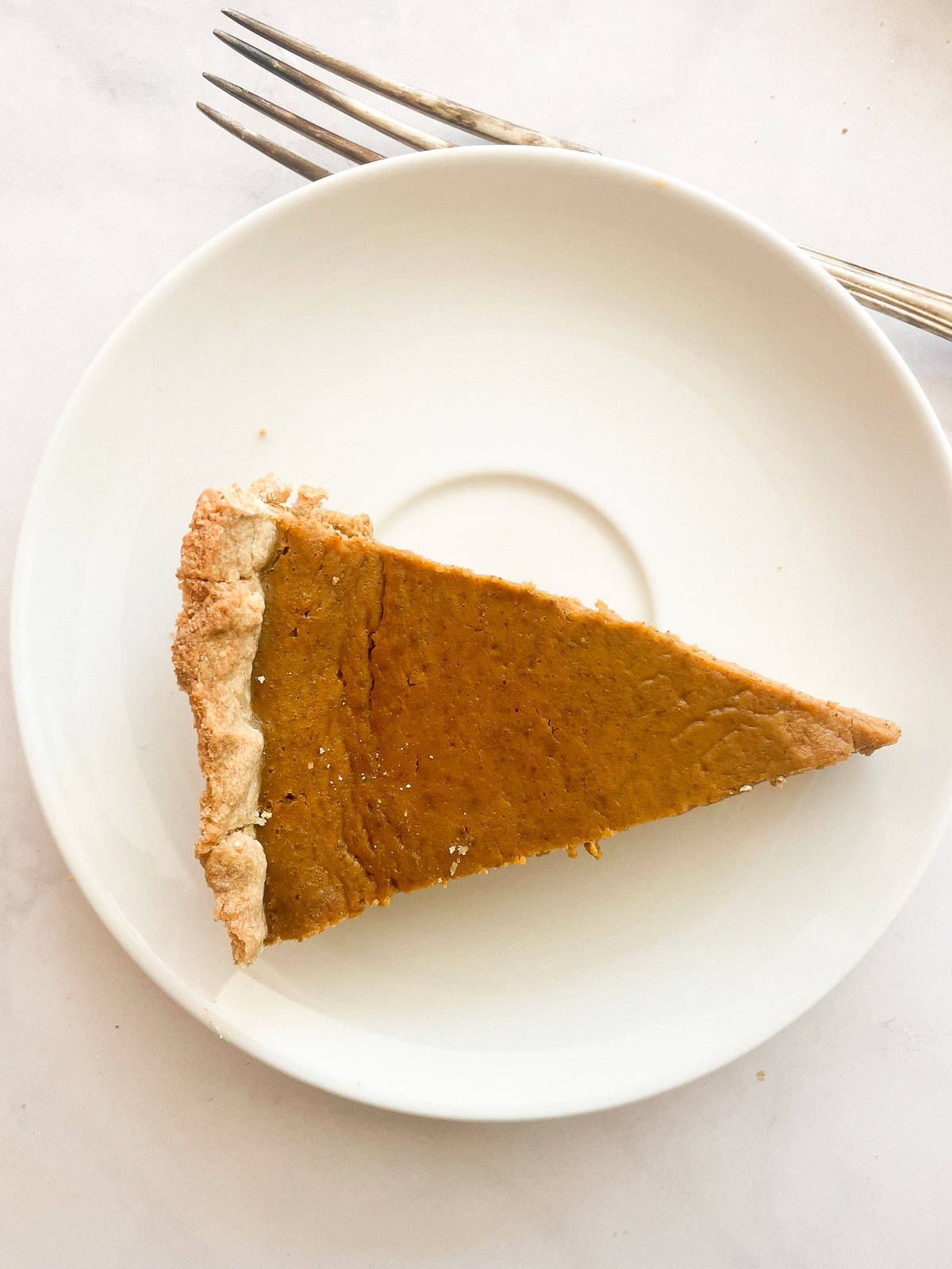 A slice of pumpkin pie on a plate.